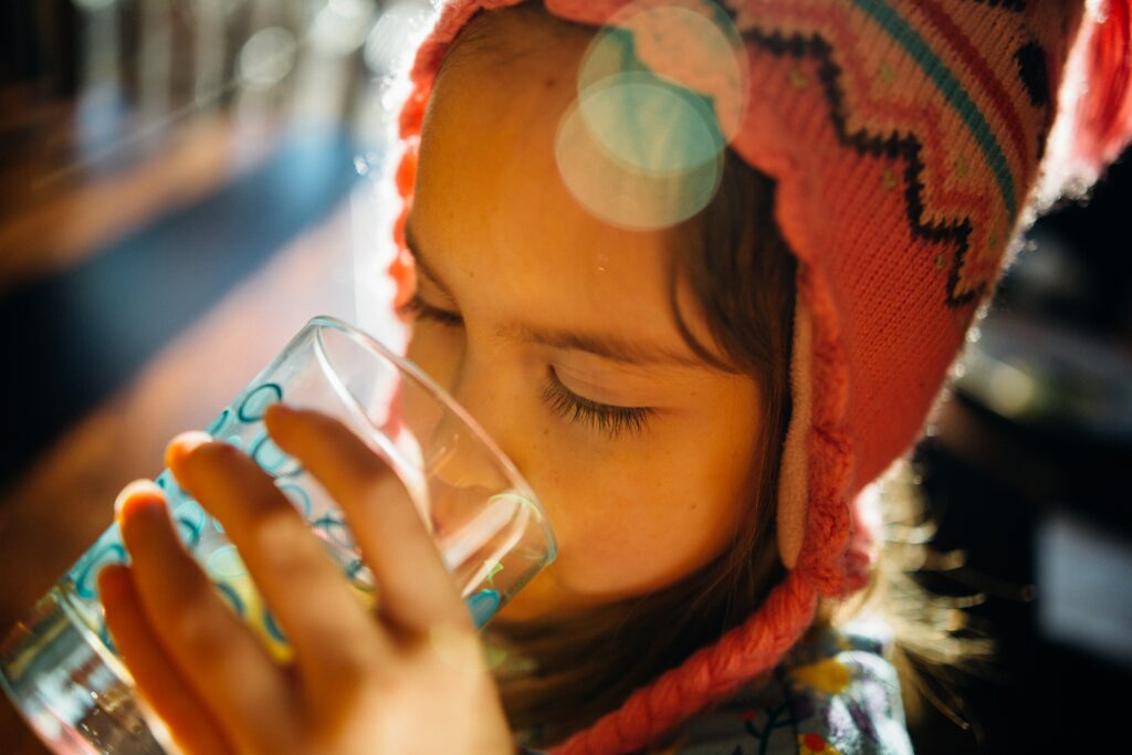 An heißen Sommertagen sollten Kinder viel Wasser trinken, damit sie nicht dehydrieren.